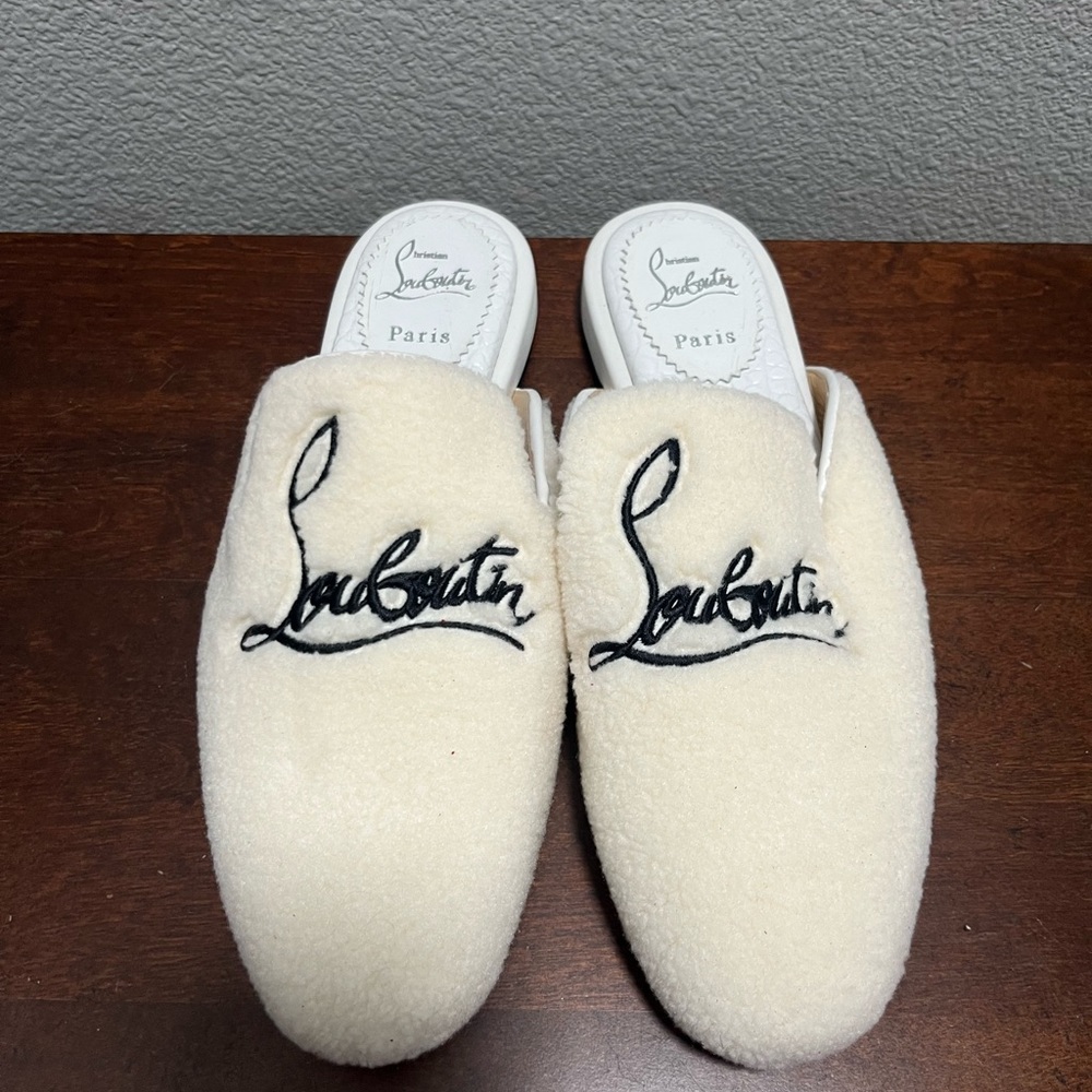 White Christian Louboutin fuzzy slippers with a hard sole